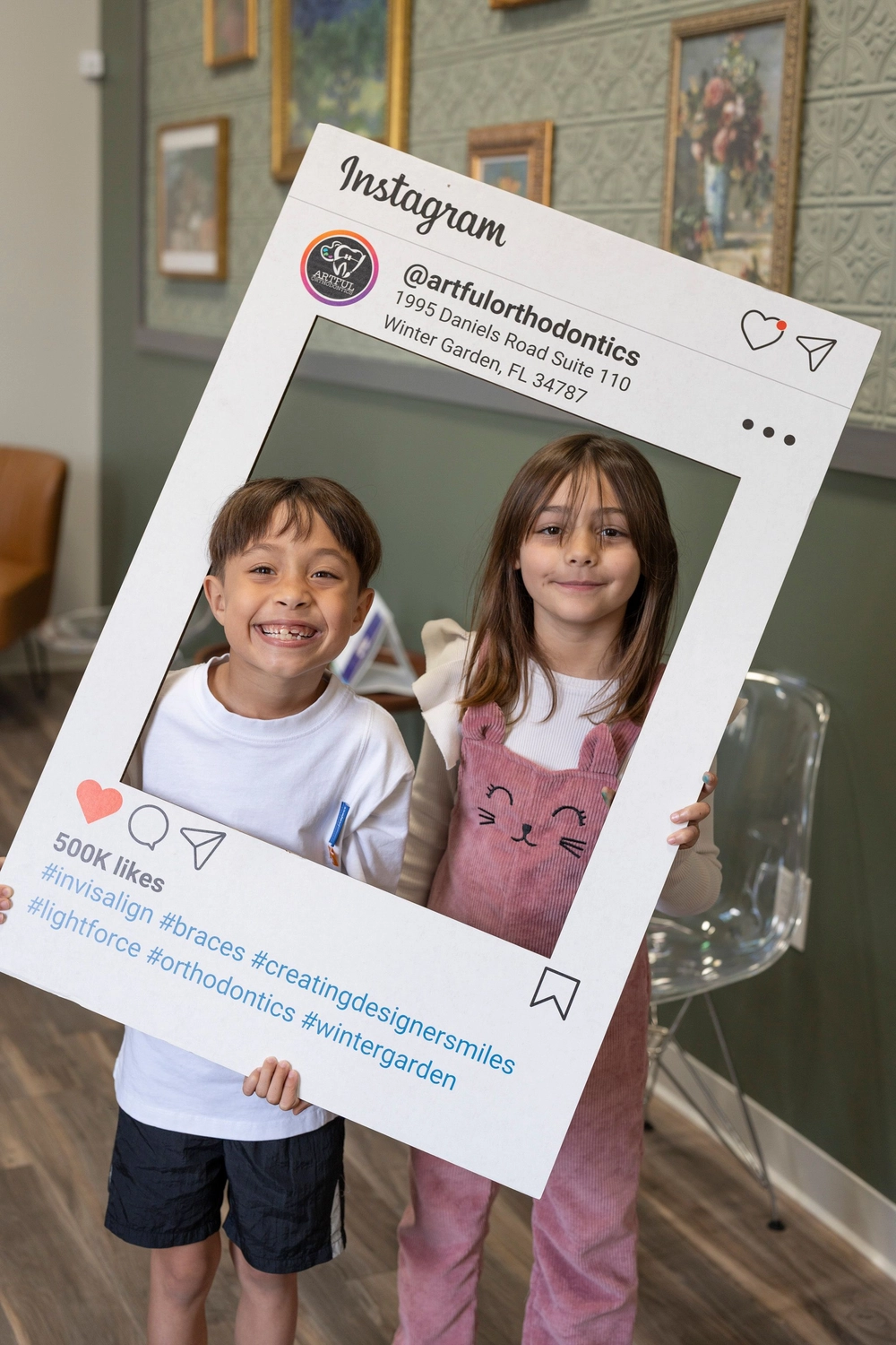 Young patients posing with the Artful Orthodontics Instagram photo frame